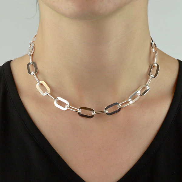 Chunky flat chain necklace in silver, worn on model to showcase its bold and modern style.