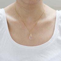 Elegant gold rose acorn pendant necklace, showcasing a luxurious design on the model.