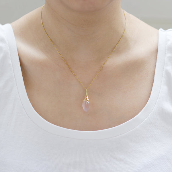 Elegant gold rose acorn pendant necklace, showcasing a luxurious design on the model.