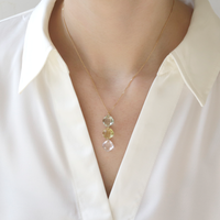 Model wearing a triple cushion-cut gemstone pendant, showcasing its vibrant mix of stones and elegant design.