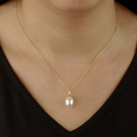 Elegant single pearl necklace with a textured feature, showcased on a model for scale and style.