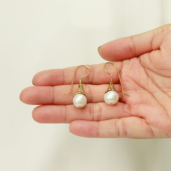 Elegant white pearl earrings with a sleek and classic design, perfect for adding a touch of sophistication to any look.