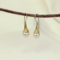Elegant white pearl earrings, featuring a classic design that adds sophistication and timeless beauty to any outfit.