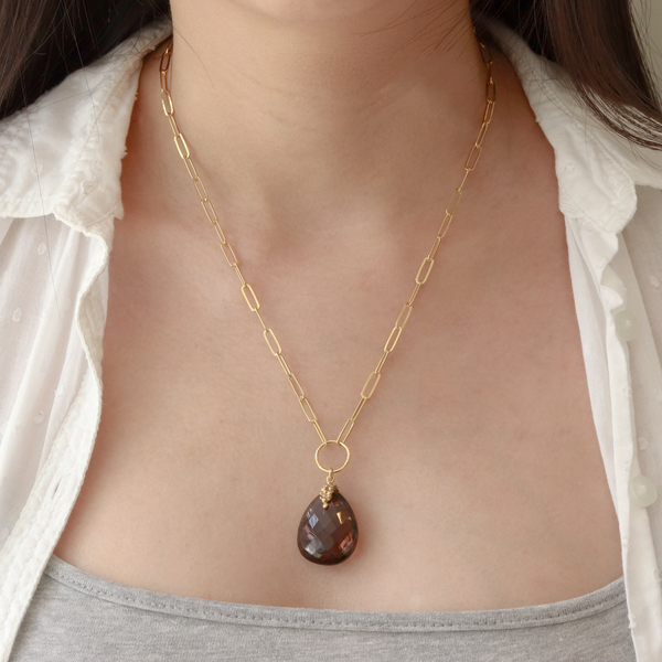 Model wearing a large pear-cut smoky quartz necklace, showcasing its elegant and sophisticated design.
